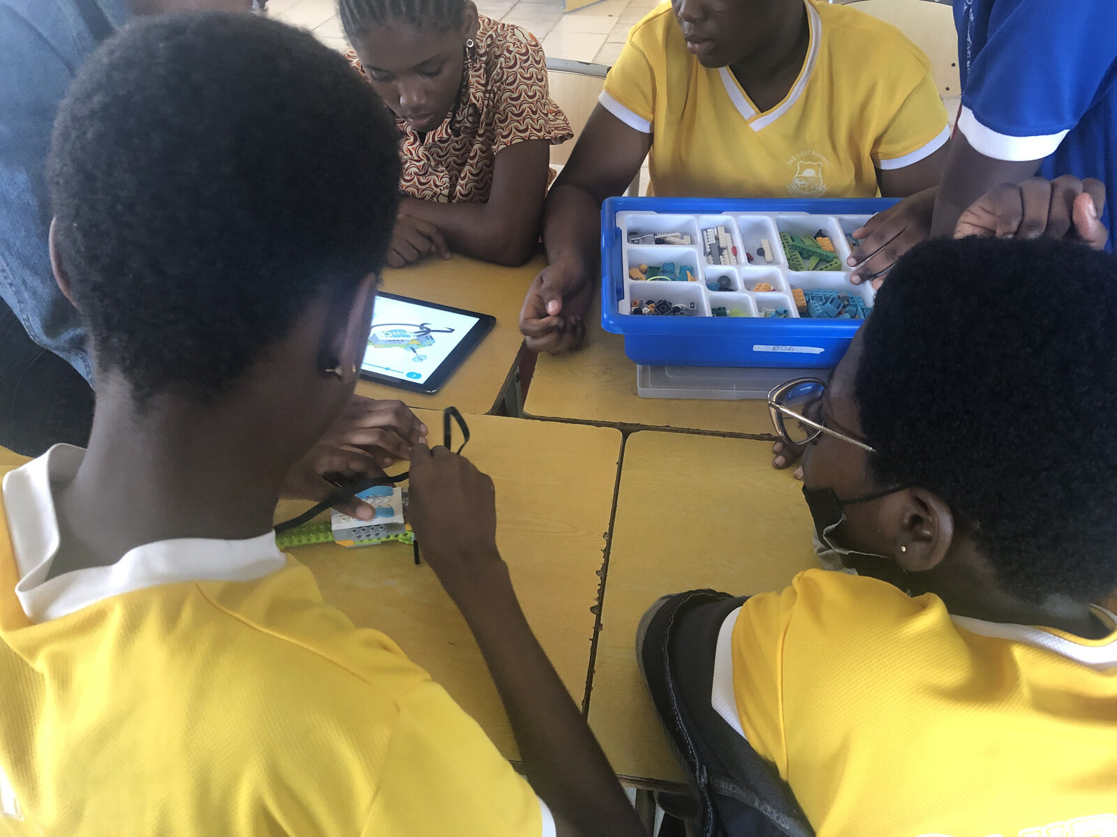 Students programming a LEGO robot with a tablet